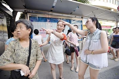 昨日,解放碑临江门,公交465的工作人员在原站台给乘客指路